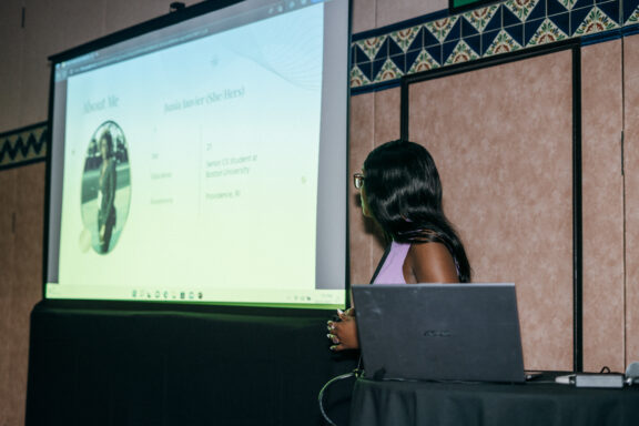 Junia Janvier presenting beside a projected slide